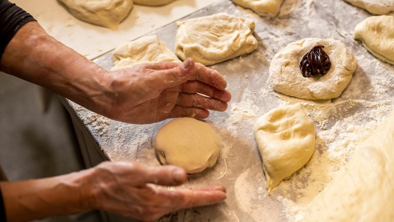Hausgemachte Germknödel im Gasthaus Rath-Smetana, © Niederösterreich Werbung/Kurt Pinter Zubereitung von Germknödeln auf bemehlter Arbeitsfläche.