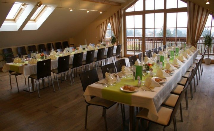 Ein festlich gedeckter Saal mit langen Tischen und Stühlen in einem Landgasthaus.