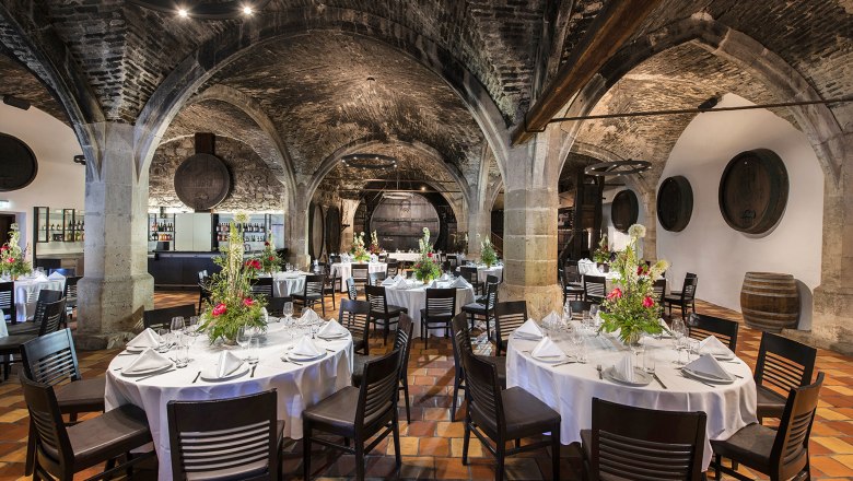 Elegant dining room with vaulted ceilings and decorated tables in Klosterneuburg Abbey.