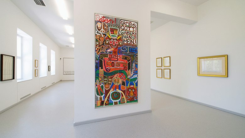 Innenansicht eines Museums mit moderner Kunst an den Wänden.
